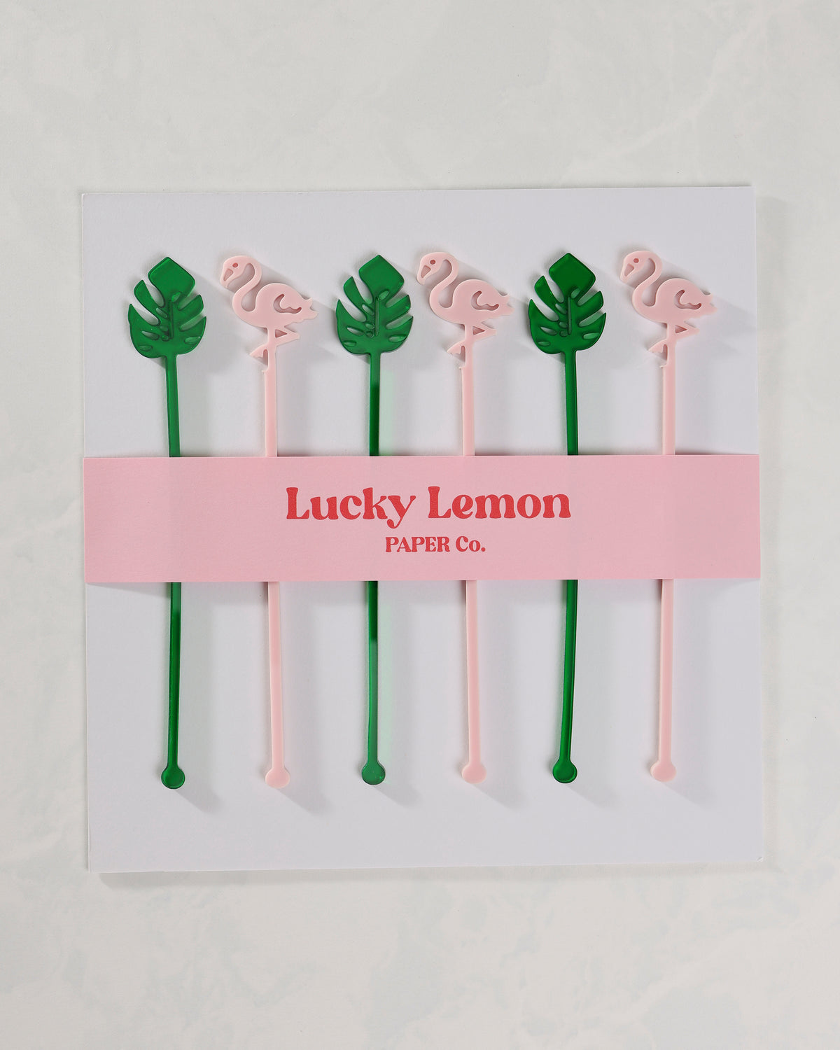 Packaged set of six pink flamingo and green palm-leaf stir sticks.