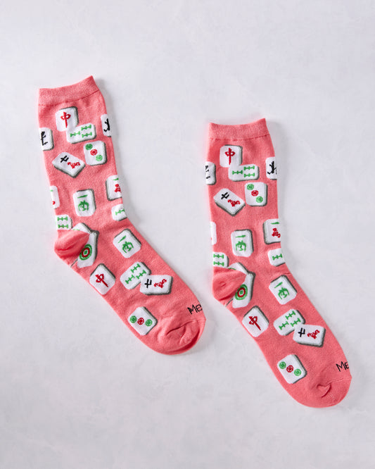 Two pink crew socks displayed separately, showing the repeated colorful mahjong tile pattern.