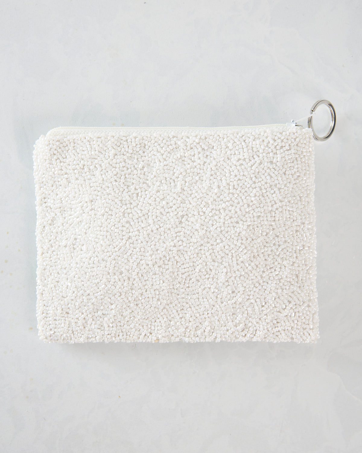 Back view of the white beaded Mahjong coin purse with a plain bead-covered surface and silver key ring.