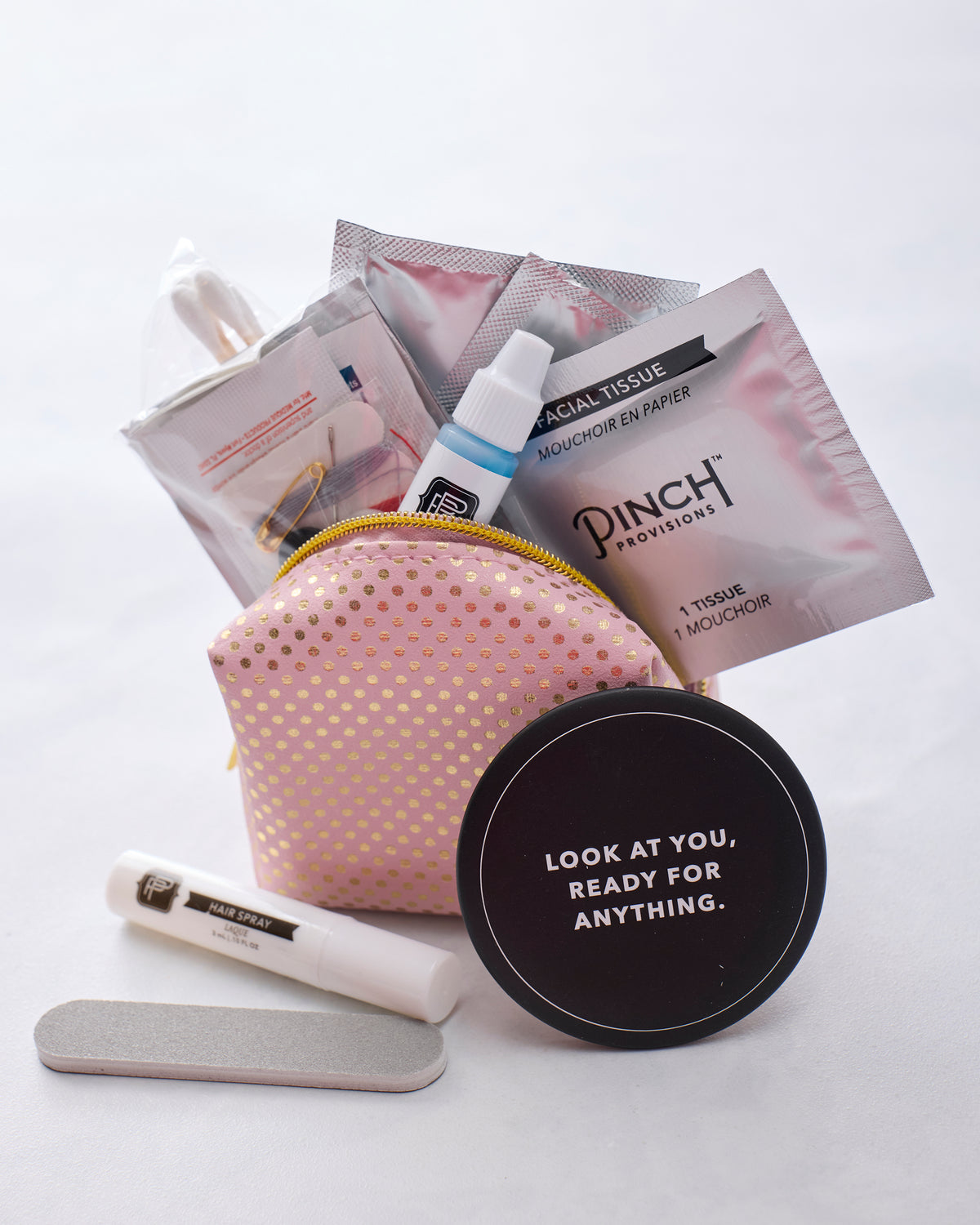 Open Pink Gold Dot Minimergency Kit showing the pink pouch and assorted emergency supplies.