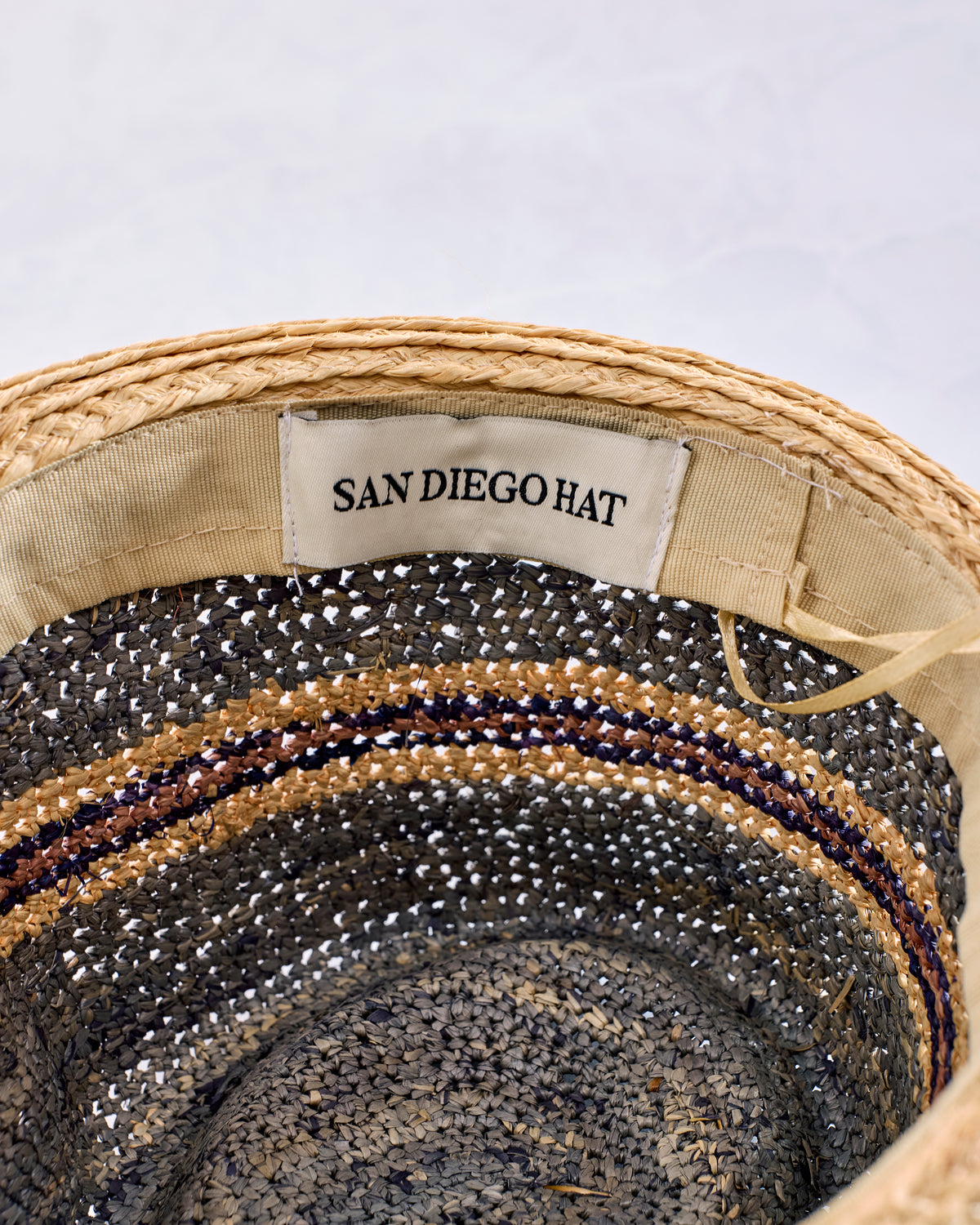 Interior detail of a crocheted striped fedora showing the sewn-in San Diego Hat label.