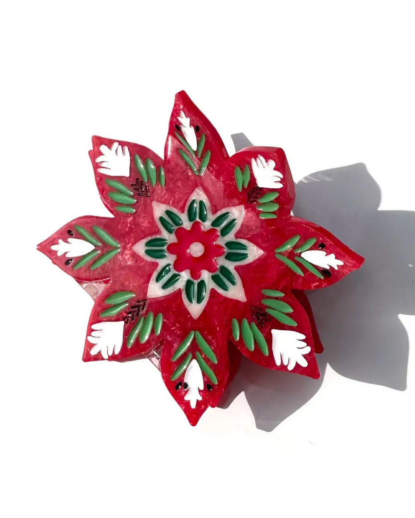 Close-up of the red, green, and white Christmas flower claw clip, showing its painted floral design.