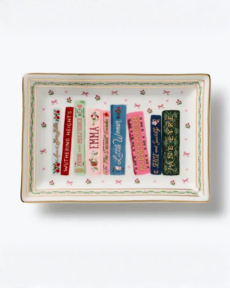 Rectangular porcelain catchall tray with a floral border and illustrated book spines, including Wuthering Heights, Pride and Prejudice, Emma, Little Women, Middlemarch, Sense and Sensibility, and Jane Eyre.