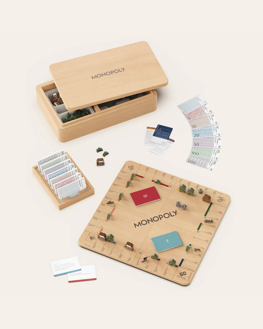 Monopoly Nordic Edition game displayed with wooden board, storage box, game pieces, cards, money, and dice.