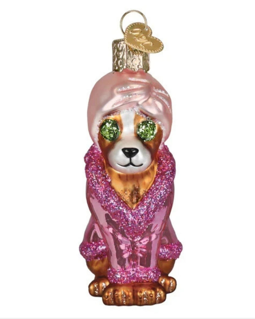 Front view of the spa dog Christmas ornament wearing a pink robe and head wrap.