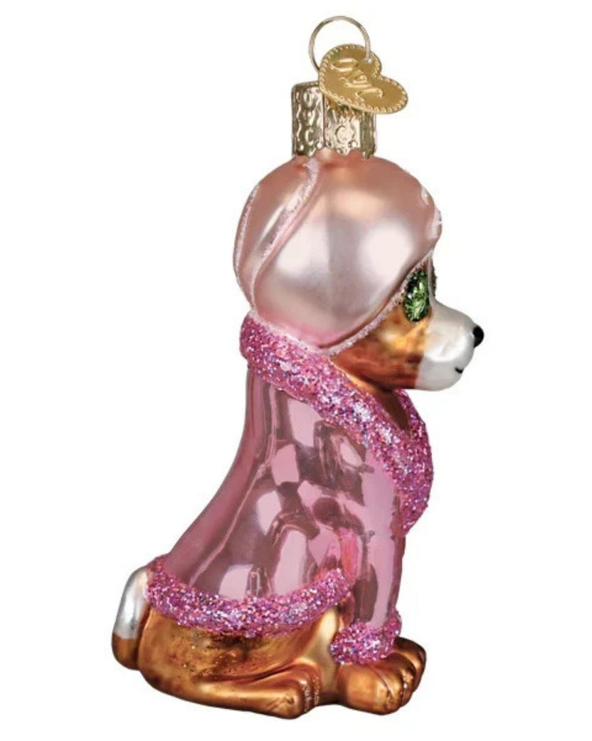 Side view of the spa dog Christmas ornament wearing a pink robe and head wrap.