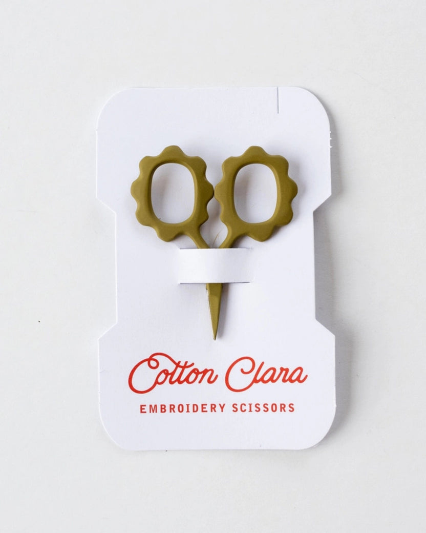 Front view of mini sunflower embroidery scissors in olive green on Cotton Clara product packaging.