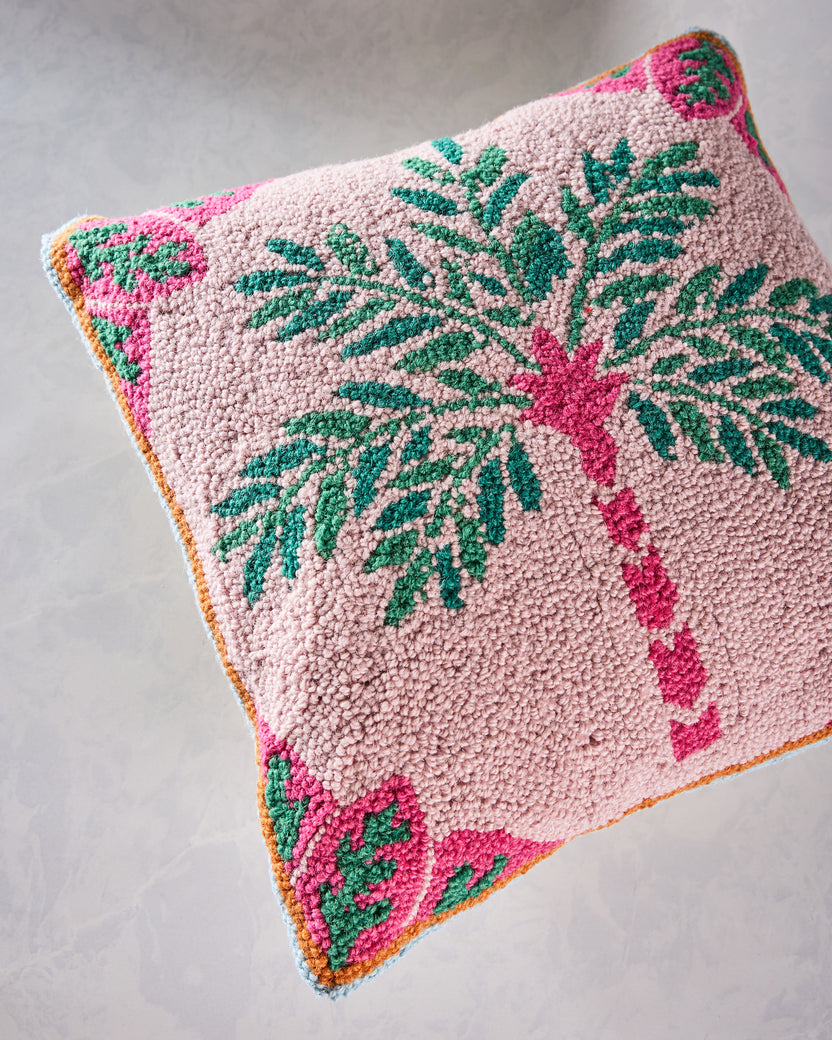 Close-up of the pink hook pillow’s palm tree design and colorful patterned border.