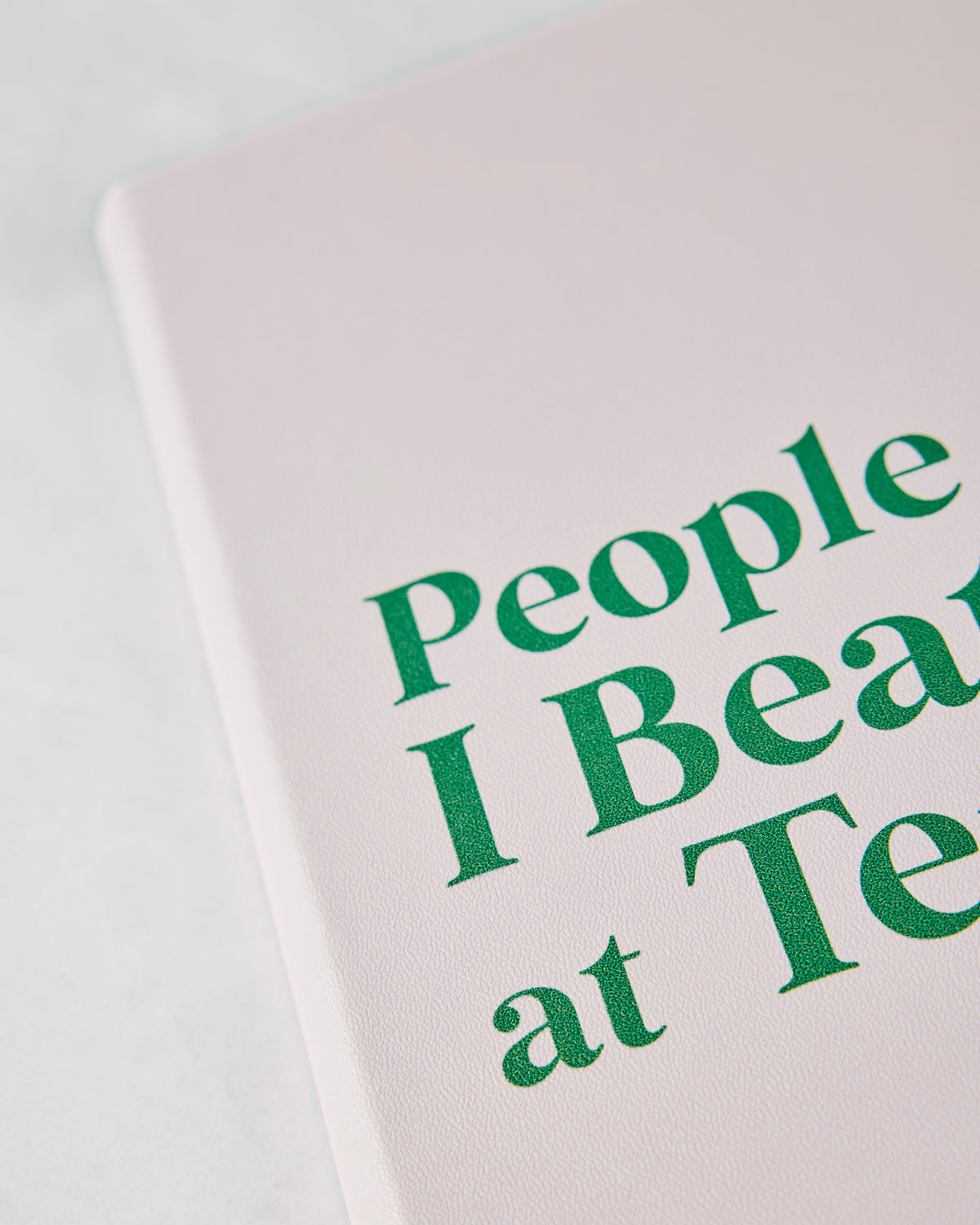 Close-up of the pink journal cover with enlarged green lettering from the title.