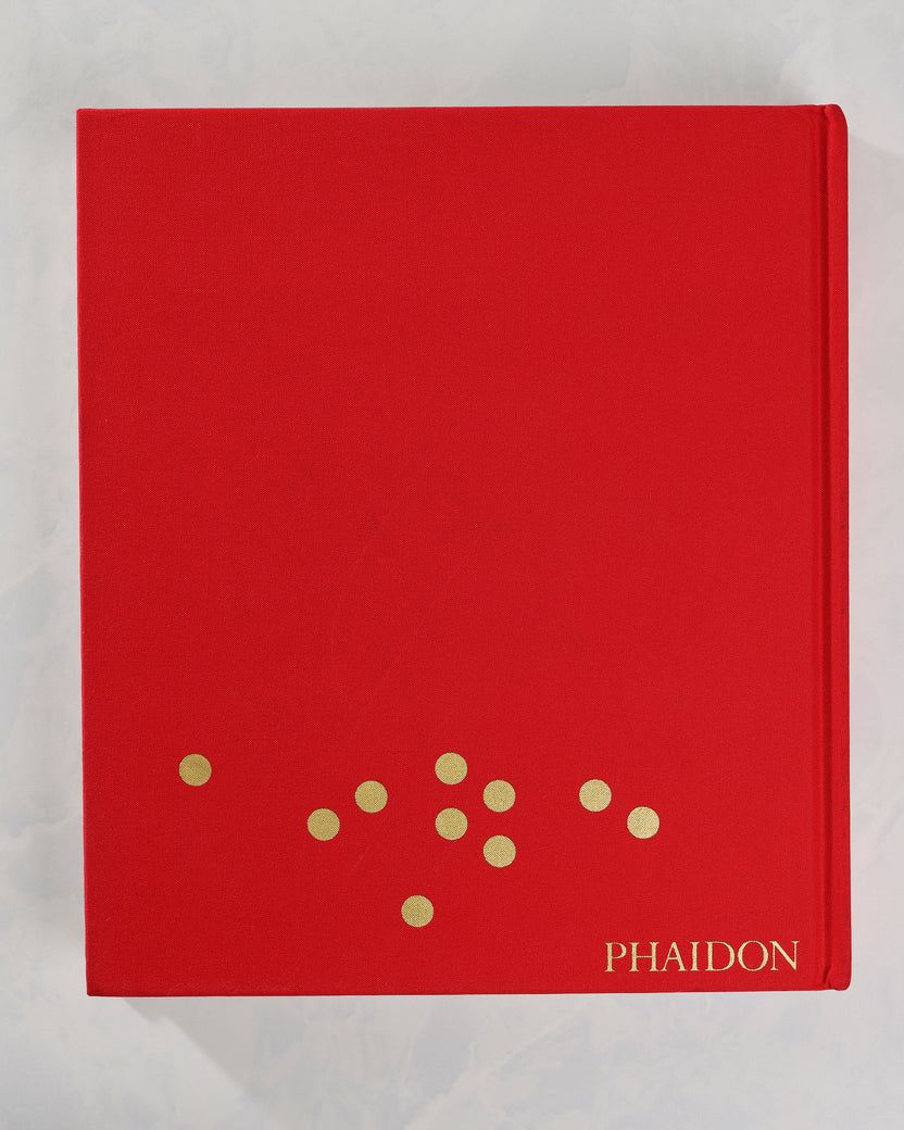 Back cover of the red Christmas Book by Phaidon, with a small arrangement of gold dots near the bottom.