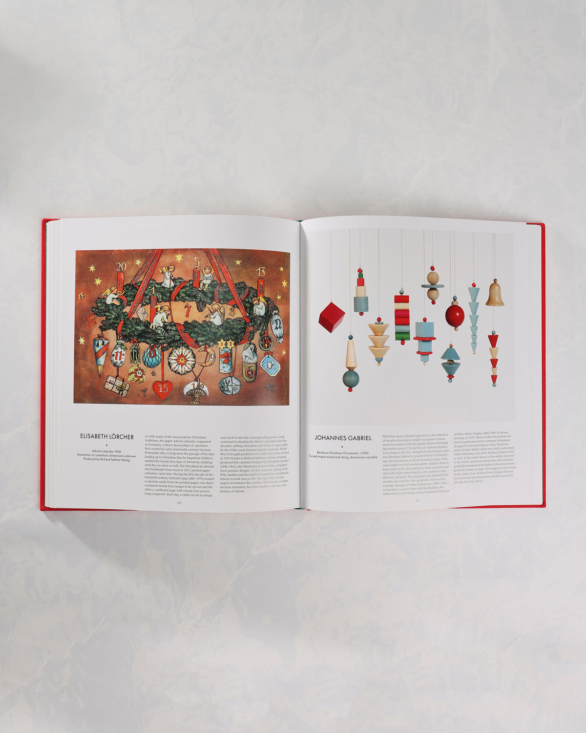 Open spread from The Christmas Book showing a vintage numbered Christmas calendar illustration beside a page of hanging geometric ornaments.