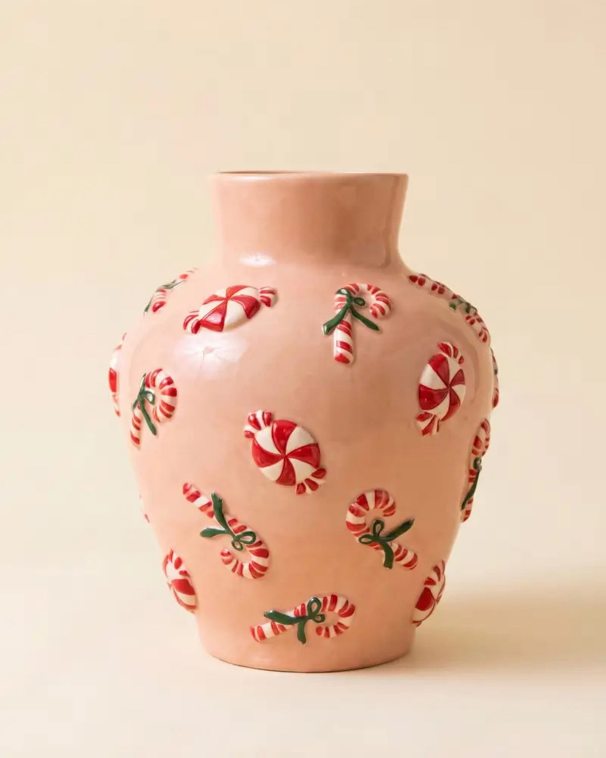 Pink ceramic vase with dimensional red-and-white peppermint and candy cane decorations