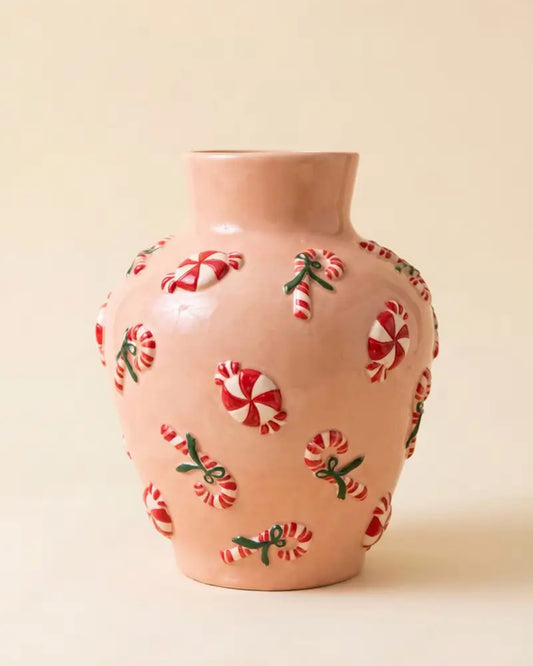 Pink ceramic vase with dimensional red-and-white peppermint and candy cane decorations