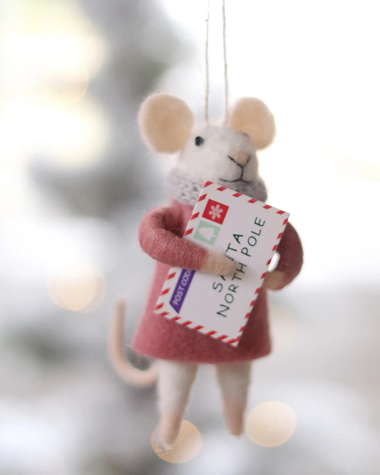 Felt mouse ornament holding a Santa North Pole envelope, shown hanging against a softly blurred background.