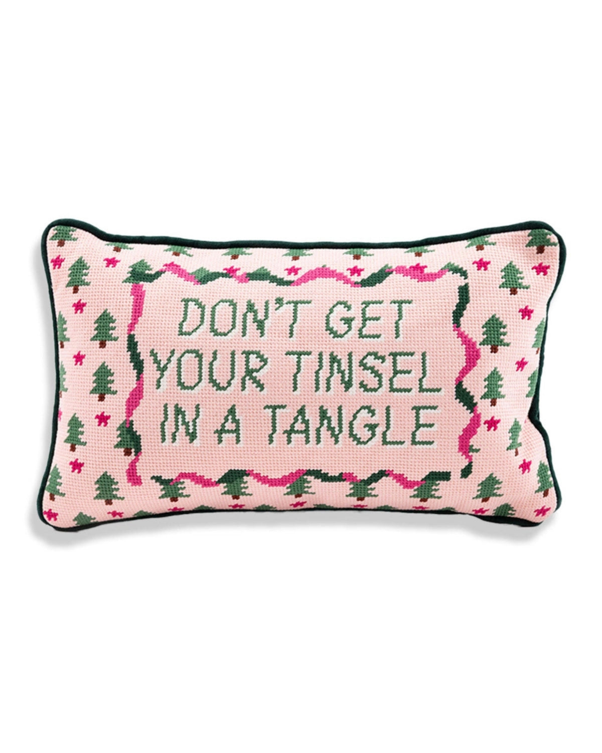 Front view of a pink needlepoint pillow reading “DON’T GET YOUR TINSEL IN A TANGLE,” with green trees and pink star motifs.