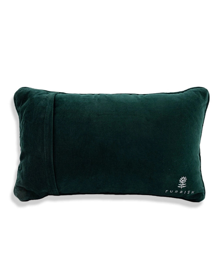 Back view of the pink needlepoint pillow in dark green velvet, with a Furbish logo near the lower right corner.
