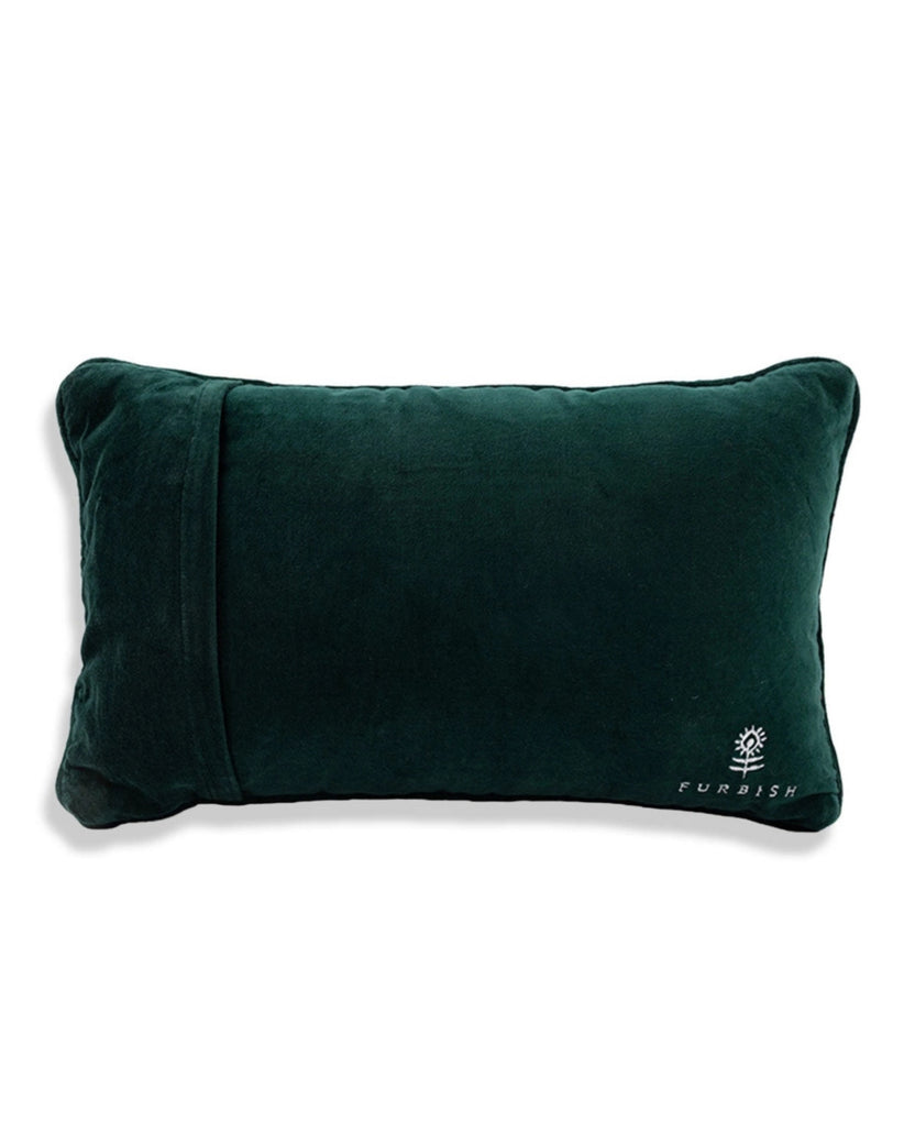 Back view of the pink needlepoint pillow in dark green velvet, with a Furbish logo near the lower right corner.