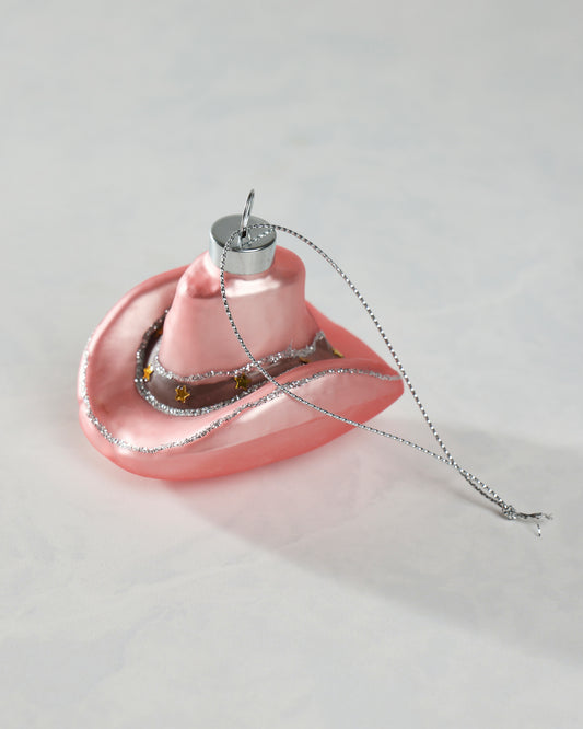 Pink cowgirl hat glass ornament with silver glitter trim, gold star accents, and a hanging loop.