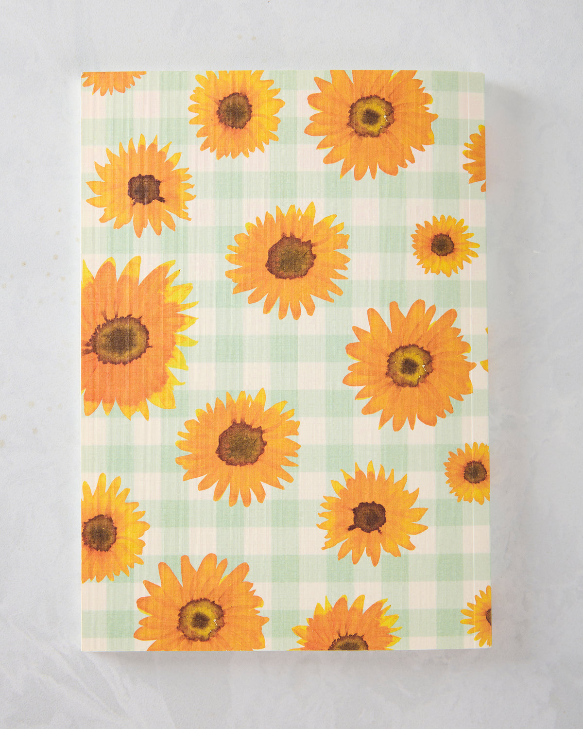 Full view of a sunflower journal with orange sunflowers on a pale green-and-white checkered cover.