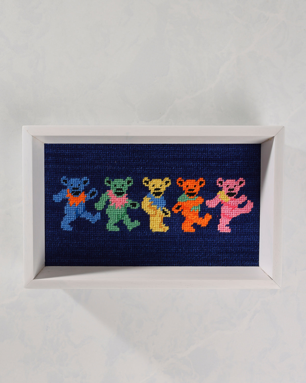 Dark navy valet tray with a white frame and a stitched design of five colorful dancing bears.
