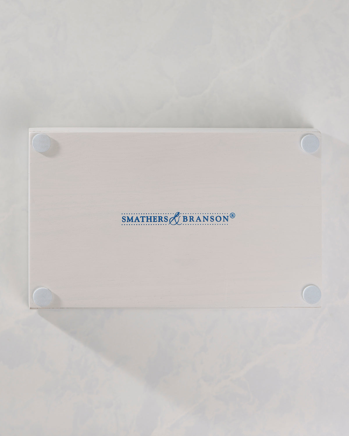 Back of the white valet tray showing four round feet and the Smathers & Branson logo.