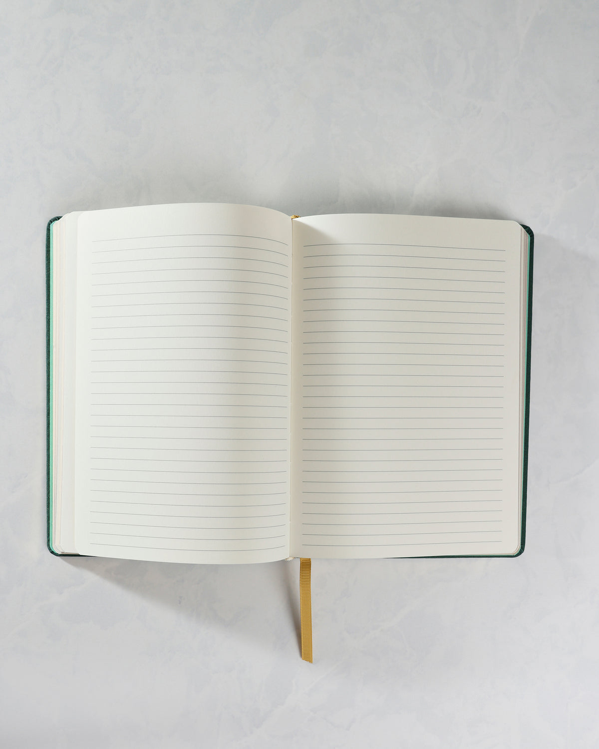 Cozy Reads journal opened to two blank ruled pages, with a gold ribbon bookmark visible at the bottom.