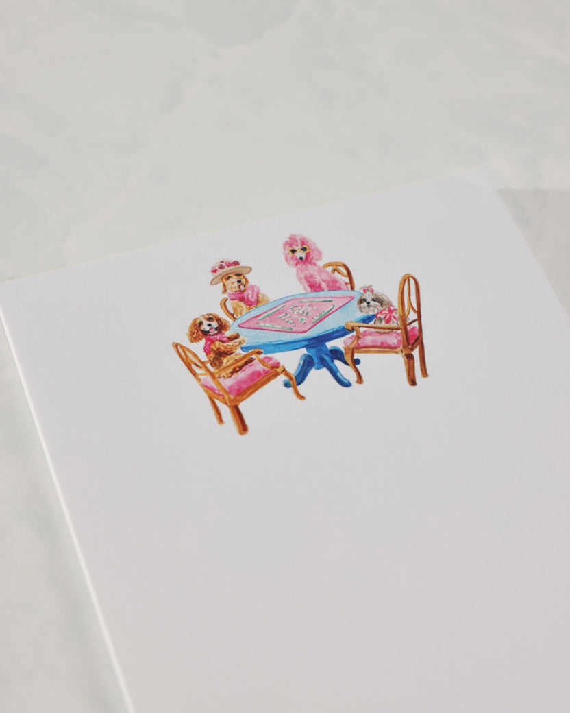 Close-up of the notepad cover illustration showing dogs seated around a blue table.