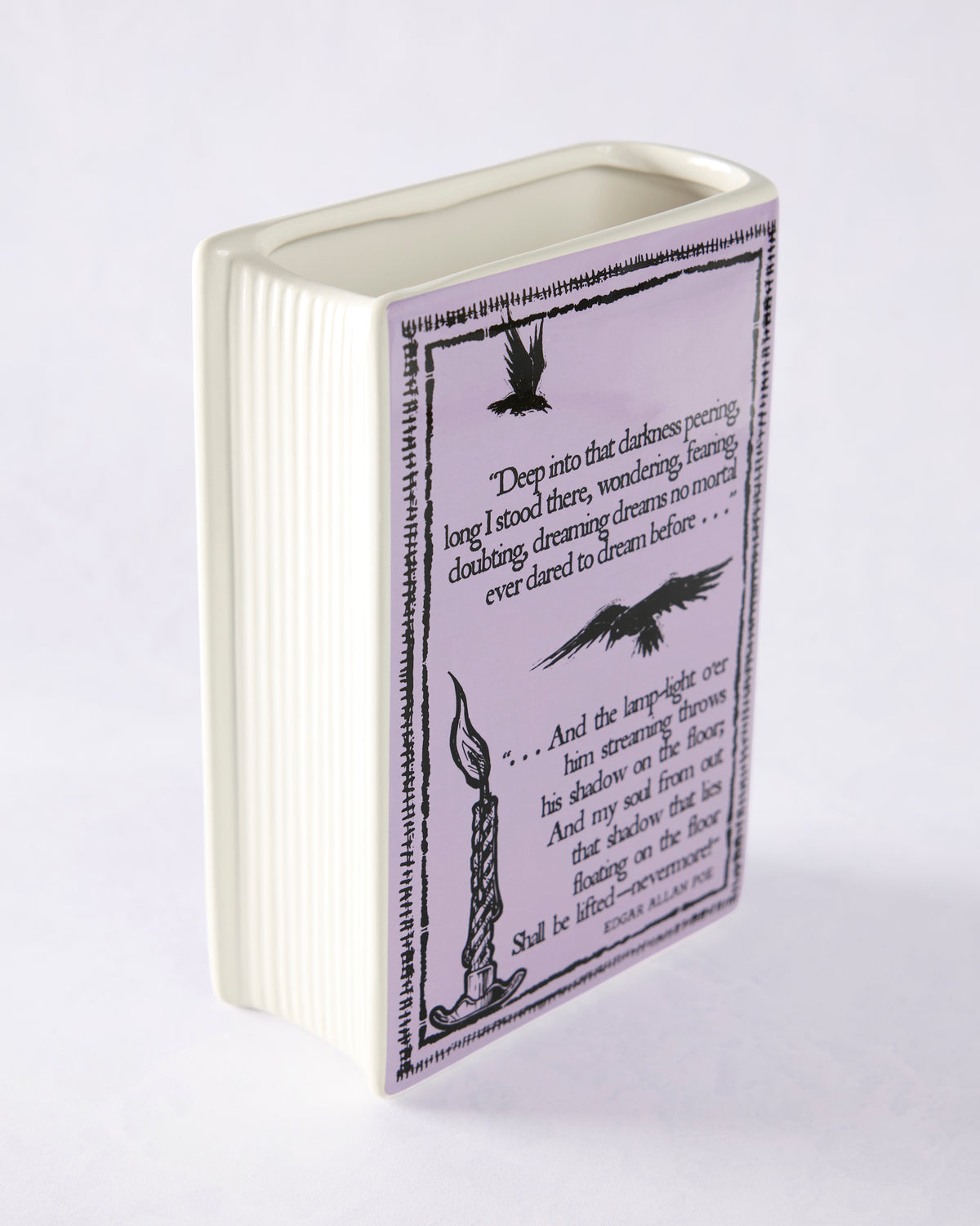 Purple ceramic book-shaped vase with a printed Edgar Allan Poe quote, raven illustrations, and a candle illustration on the front.