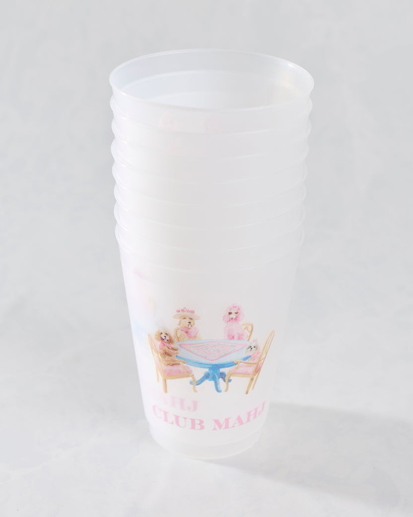 White frosted cup featuring an illustration of dogs gathered around a mahjong table and pink lettering.
