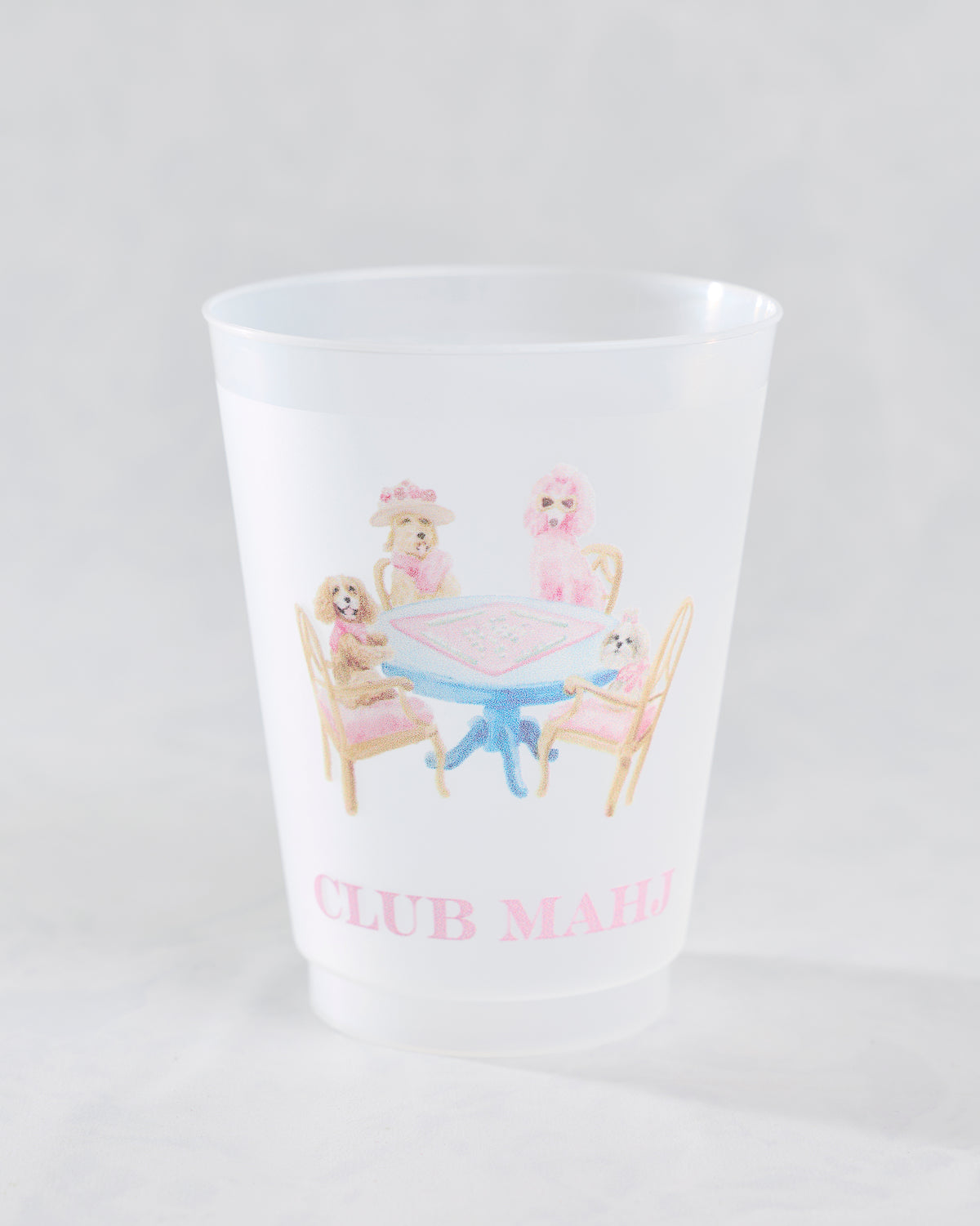 Front view of a white frosted cup with dogs gathered around a mahjong table and the words Club Mahj.