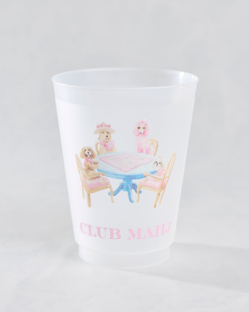 Front view of a white frosted cup with dogs gathered around a mahjong table and the words Club Mahj.