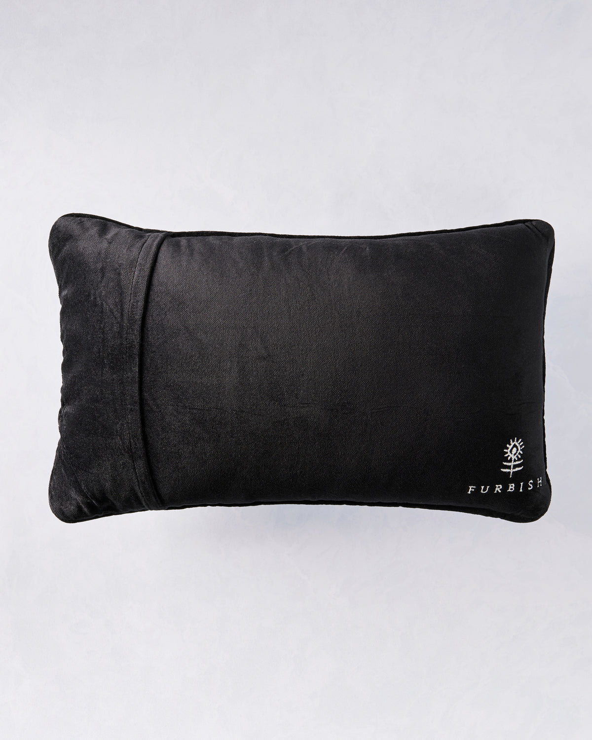 Back view of the black rectangular pillow with the Furbish logo at the lower right.