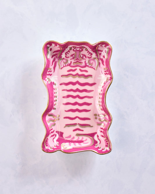 Top view of a white Tibetan tiger trinket dish with a pink tiger illustration and gold-colored edging.