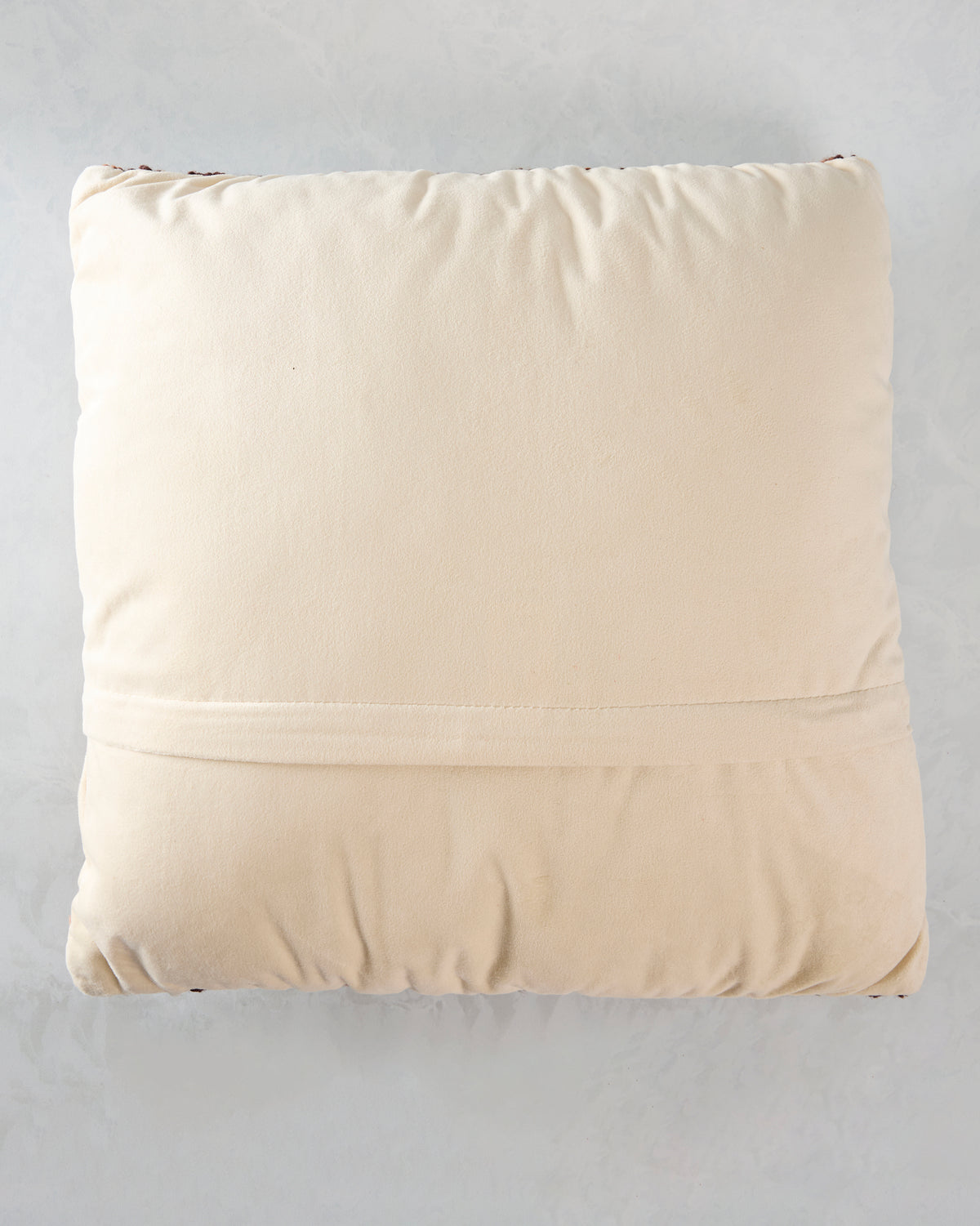 Back of the square fox pillow, showing a plain cream-colored backing and stitched lower seam.