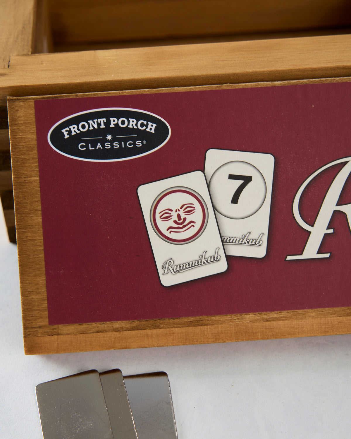 Close-up of the Rummikub box showing the Front Porch Classics logo and illustrated game tiles.