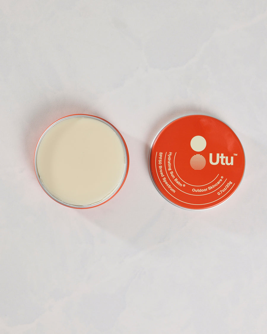 Open Utu sun balm tin beside its orange lid, viewed from above.