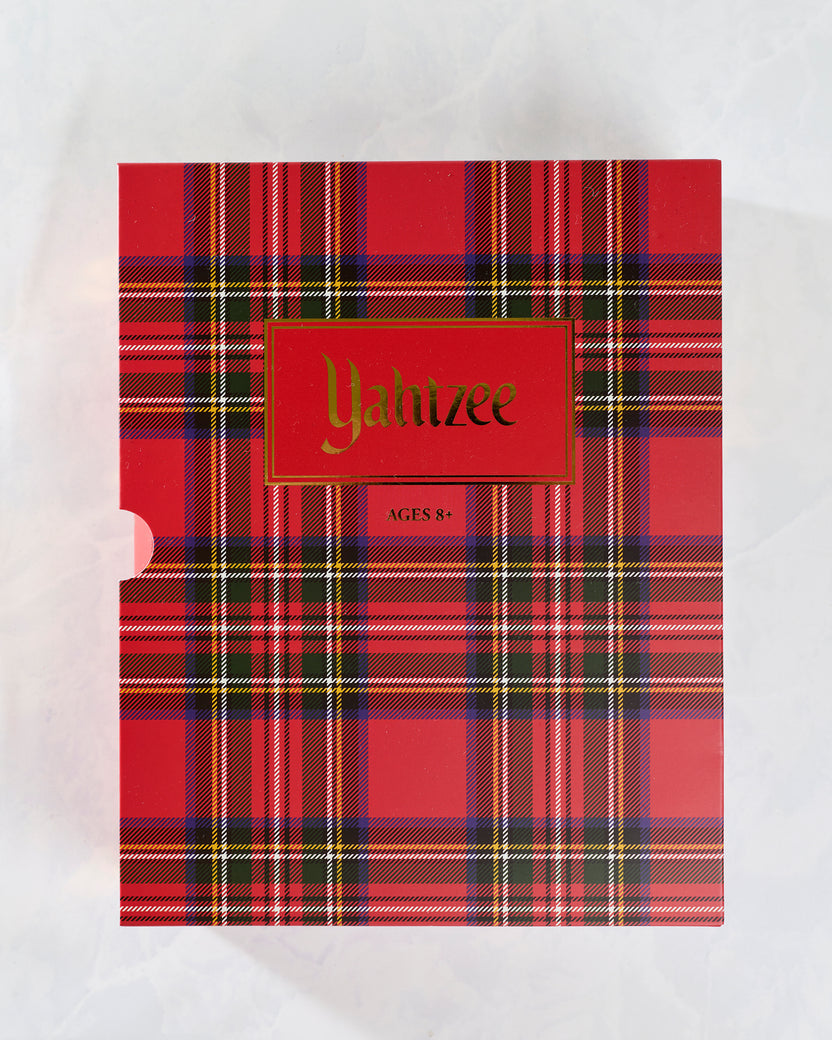 Front view of the red plaid Yahtzee Holiday Bookshelf Edition game case labeled Yahtzee and Ages 8+.