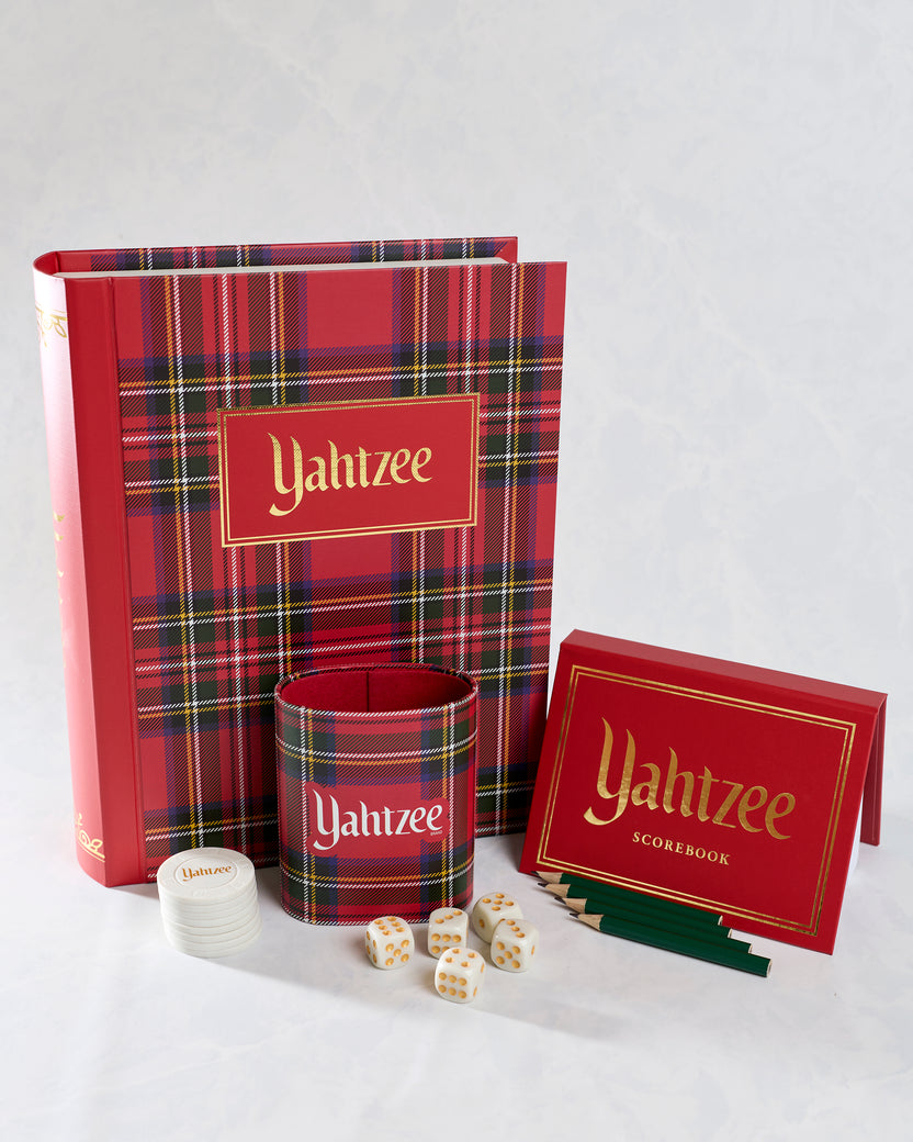 Yahtzee bookshelf game set displayed open with plaid case, dice cup, dice, chips, scorebook, and pencils.