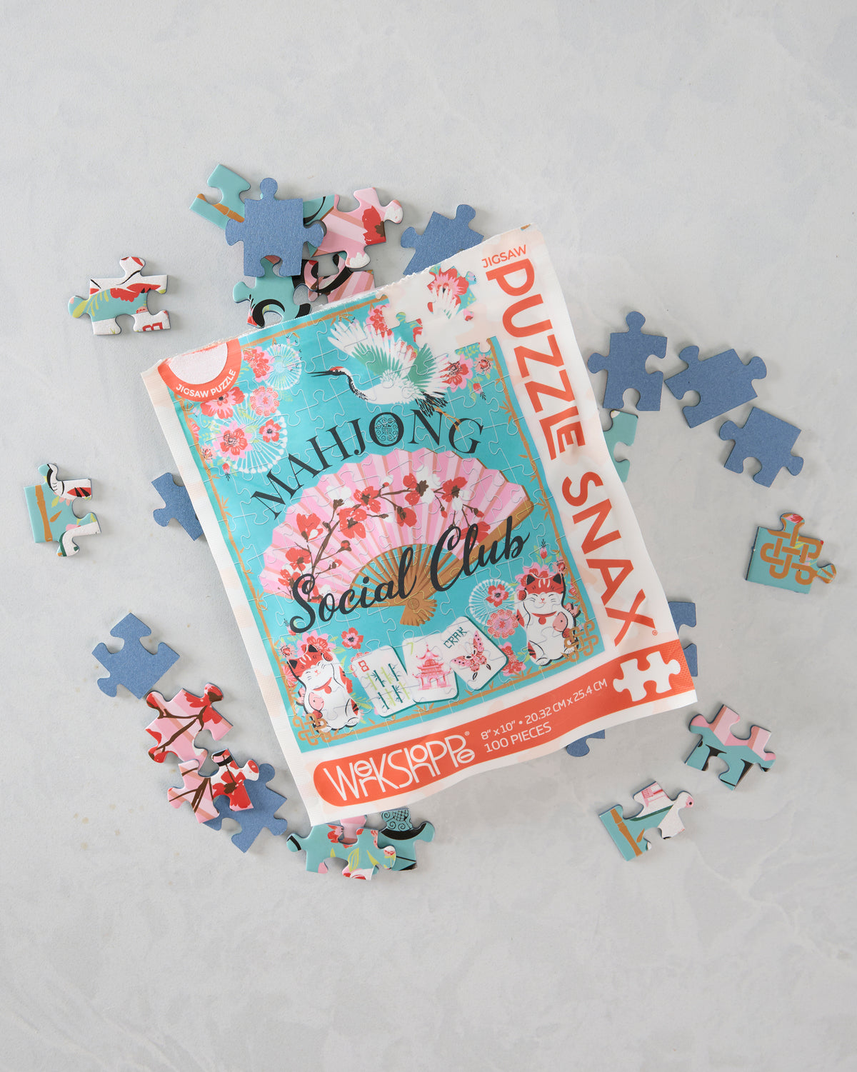 Mahjong Social Club puzzle pouch surrounded by loose jigsaw pieces.