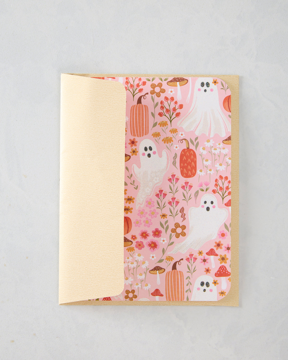 Open greeting card with a pink floral Halloween pattern featuring ghosts, pumpkins, mushrooms, and flowers.