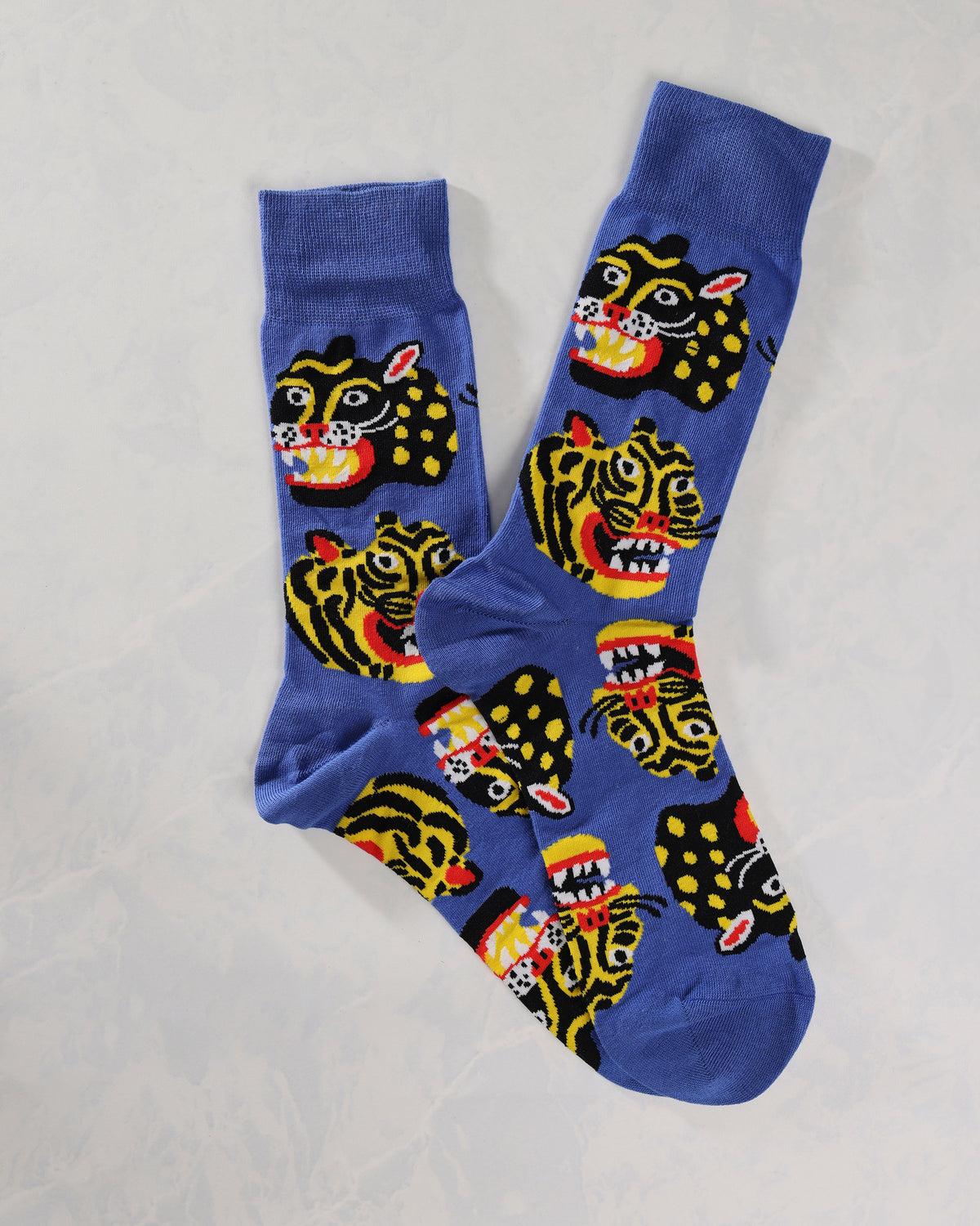 Blue socks with repeating black-and-yellow wild cat faces, shown overlapping.