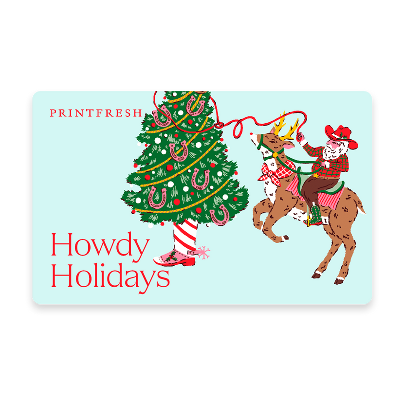Illustrated gift card with a holiday tree and a cowboy riding a reindeer, labeled “Howdy Holidays.”