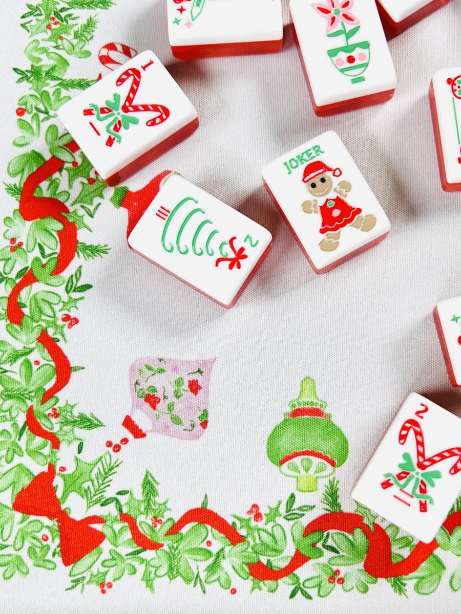 Close-up of the Holly Jolly Christmas Mahjong mat with holiday-printed Mahjong tiles, including a candy cane, ornament, and joker tile.